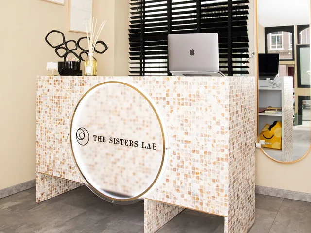 Balie met het logo van The Sisters Lab in hun salon in Amsterdam