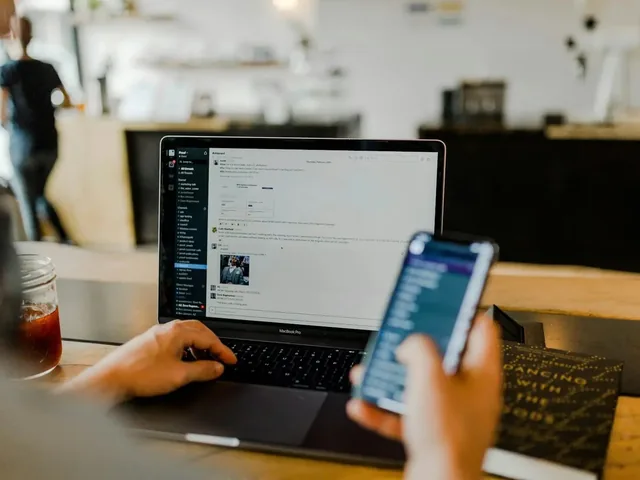 Iemand volgt de status van IT-systemen op een laptop en een telefoon, zoals in de kennisbank van Twist IT