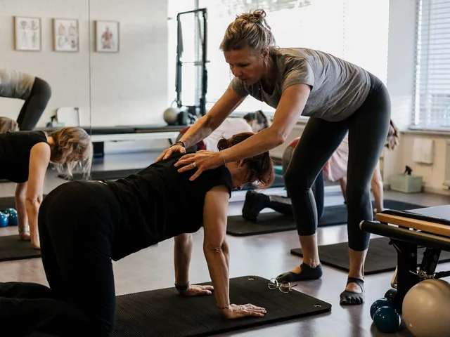 Instructeur begeleidt een cursist tijdens een pilatesles in de studio van Essenz Pilates in Eindhoven